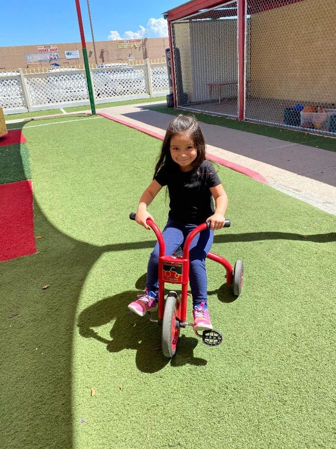A toddler on a tricycle
