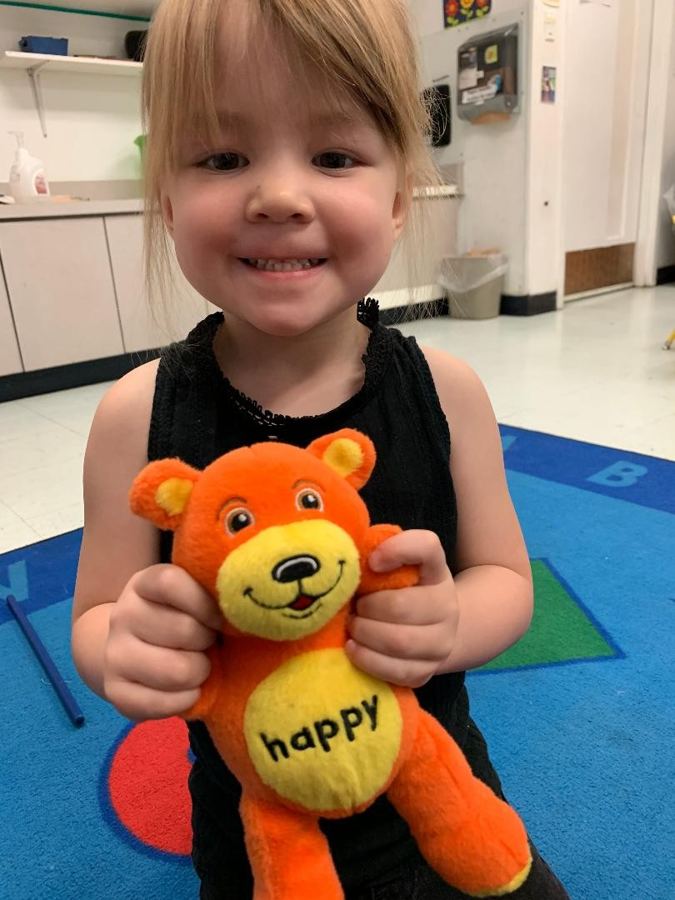 A toddler hugging a teddy bear