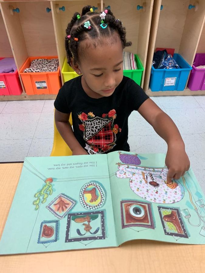 A child reading a picture book at the table